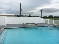 4 foot closed picket vinyl pool fence transitioned into 6 foot privacy vinyl fence around a pool area