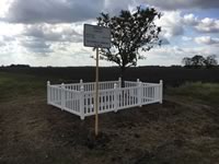 Custom built closed picket vinyl fence around a cemetery plot